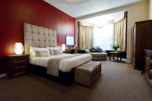 彼得伯勒明珠大酒店的一间卧室设有一张红色墙壁的大床