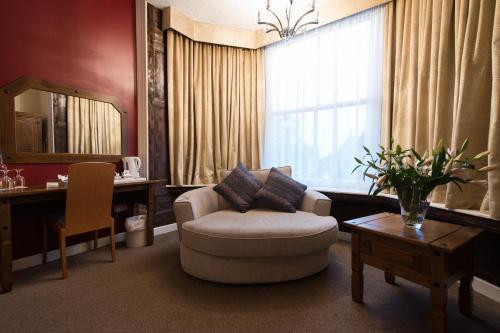 彼得伯勒明珠大酒店的客厅配有椅子、桌子和镜子