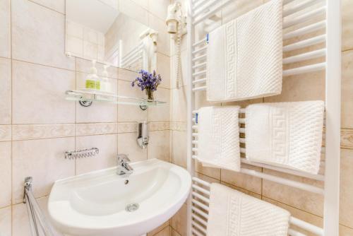 塞格德卡塔酒店的白色的浴室设有水槽和毛巾。