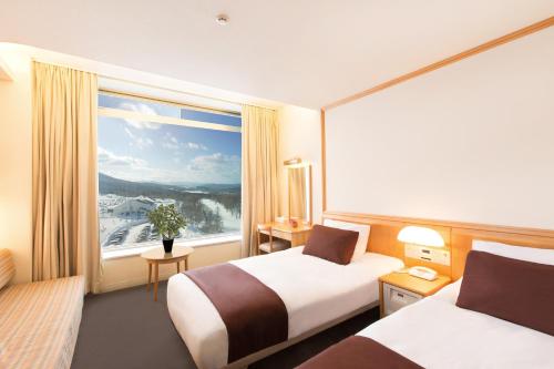 鲹泽町罗克伍德Spa及酒店的酒店客房设有两张床和大窗户。