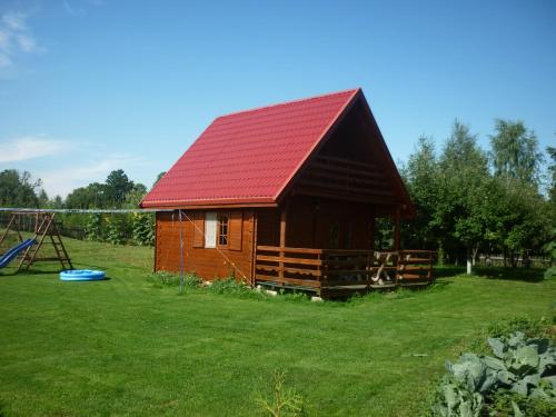 厄尔科Gospodarstwo Agroturystyczne & SPA z Alpakami的小屋设有红色屋顶和游乐场