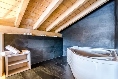 穆尔吉亚纳格斯酒店的浴室配有白色浴缸和木制天花板