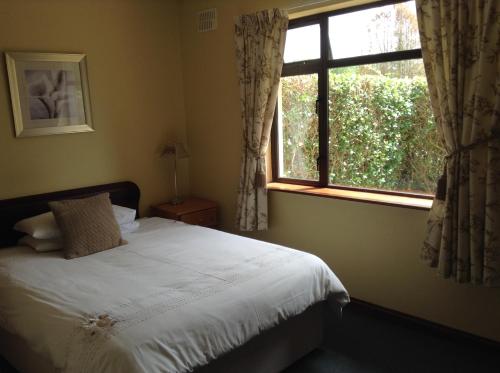 肯梅尔Riverlodge Self Catering的一间卧室设有一张床和一个窗口