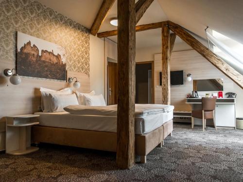 瓦赫河畔比斯特里察Hotel Gino Park Palace的一间卧室配有一张大床和一张书桌