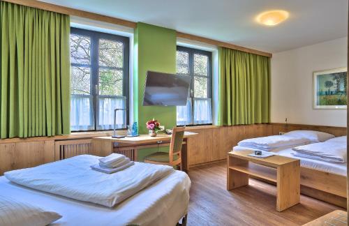 伊斯马宁祖尔姆勒酒店的客房设有两张床、一张桌子和一台电视机。