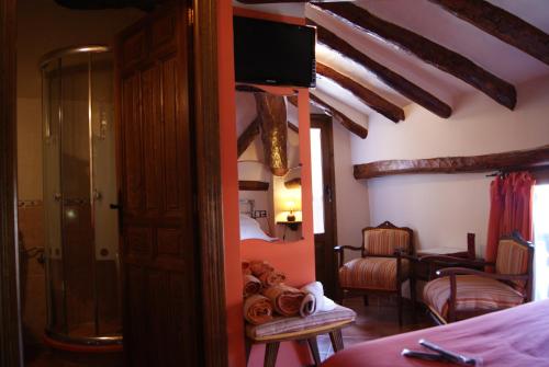 AlcorisaHotel Casa de la Fuente的客房设有带一张床和电视的卧室。