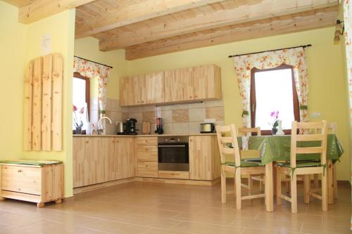 海吉克BONI APARTMAN Hegykő的厨房配有木制橱柜和桌椅