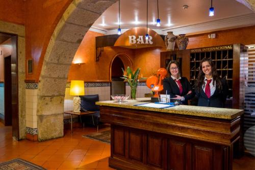 波尔图波尔图国际港务酒店的两名妇女站在餐厅酒吧