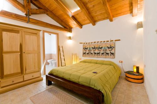 夸尔图丘B&B Stentadì的一间卧室设有一张床和木制天花板