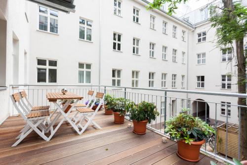 柏林托斯特拉塞舒适公寓的阳台配有桌椅和植物
