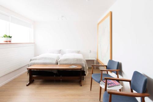 劳加尔Natura Apartments的一间卧室配有一张带桌子和两把椅子的床