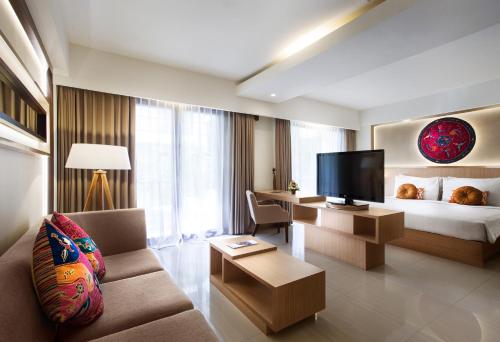 塞米亚克水明漾日落感受酒店的酒店客房配有床、沙发和电视。