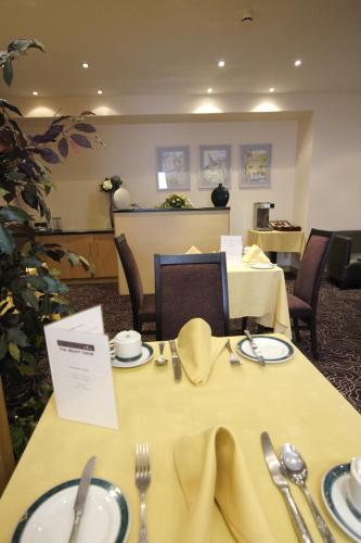 柯克沃尔阿尔伯特酒店的一间用餐室,配有两张桌子和餐具