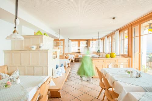 多恩比恩Hotel Dreiländerblick Dornbirn的带2张桌子的房间和1个带窗户的厨房
