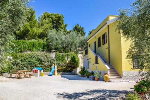 维耶斯泰Alba Del Gargano Home的黄色的建筑,设有游乐场和桌子