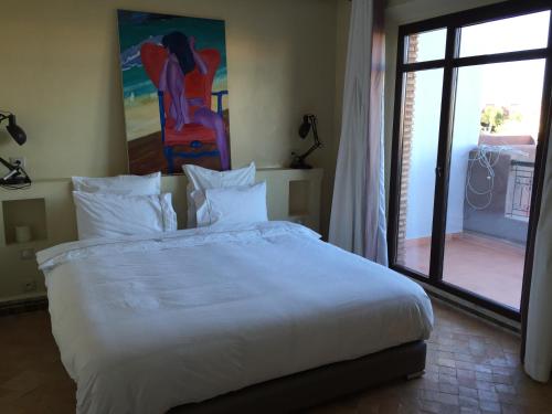 Ala el MaDar Carissa的卧室配有一张白色大床和滑动玻璃门