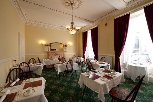 爱丁堡本多兰宾馆的一间设有白色桌椅的用餐室