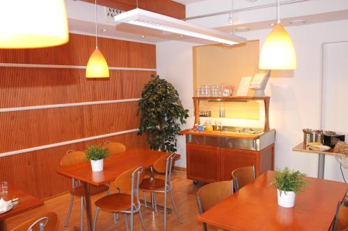 佩洛雅堪果洛汽车旅馆的餐厅设有木桌、椅子和柜台