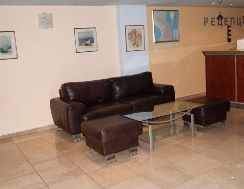 布尔加斯福斯酒店的客厅配有真皮沙发和玻璃桌