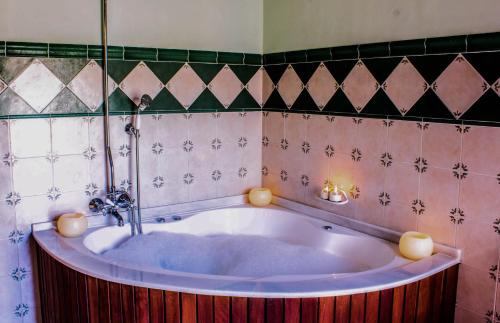 Alcalá de la Jovada拉丰特德尔卡拉旅馆的带浴缸的浴室和瓷砖墙