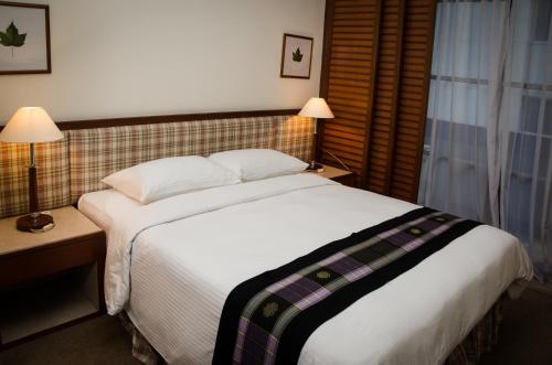 吉隆坡枫叶套房的卧室设有一张白色大床和一扇窗户。