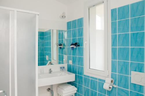 圣特雷莎加卢拉梅塔酒店 的蓝色瓷砖浴室设有水槽和镜子