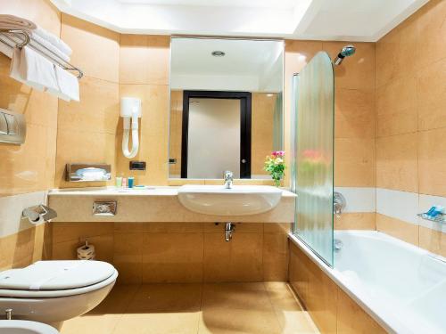 罗马Hotel IMPERATORI的浴室配有盥洗盆、卫生间和浴缸。
