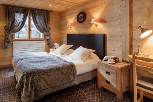 大博尔南Chalet-Hotel et Spa Le Delta的一间卧室设有一张床和木墙