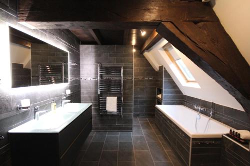 莱顿Boutique Hotel Steenhof Suites - Adults Only的浴室配有两个盥洗盆和浴缸。