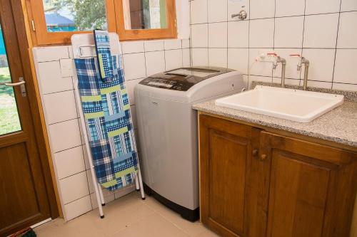 圣马丁德洛斯Sherpa Hostel的厨房配有洗衣机和水槽