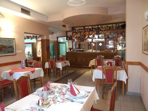 诺维萨德娜莎提维达瓦宾馆的一间带桌椅的餐厅和一间酒吧
