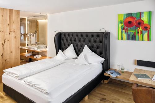 洛豪弗里奇山上酒店 - 仅限成人入住 的一间卧室配有一张白色大床和黑色床头板