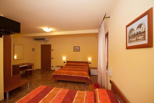 阿西西桑图希客房酒店的酒店客房设有两张床和电视。