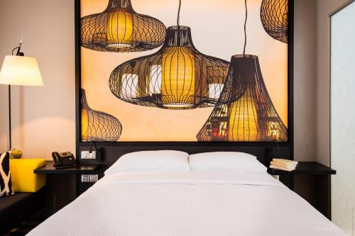 法兰西堡西蒙酒店的一间卧室配有一张挂在床上的灯