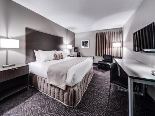 High River高河赫瑞泰格酒店及会议中心的酒店客房设有一张大床和一张书桌。