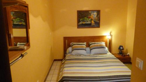 库鲁塔奇尼4号旅馆的一间卧室配有一张带条纹床罩的床