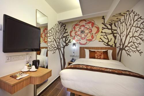 新加坡Hotel Clover The Arts的卧室设有1张带电视的床,墙上有树木