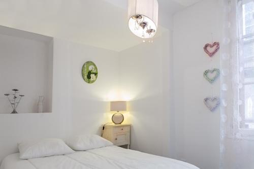 翁弗勒尔带露台公寓的白色卧室配有床和灯