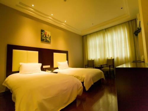 顺义格林豪泰北京市顺义区新国展快捷酒店的酒店客房,配有两张带白色床单的床