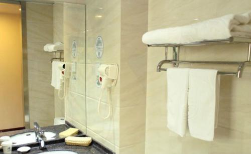 顺义格林豪泰北京市顺义区新国展快捷酒店的浴室配有盥洗盆、镜子和毛巾