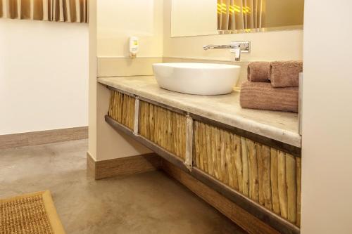 塞斯瑞姆沙漠箭袋营旅馆的木制柜台上带白色水槽的浴室