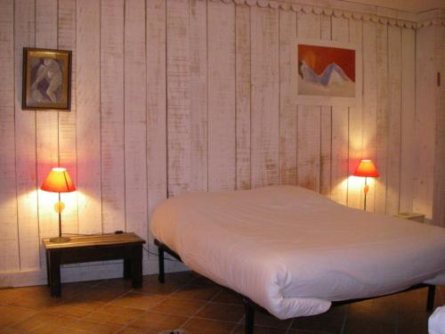 La CabanasseLa Maison Bleue的卧室配有白色的床和两盏灯。