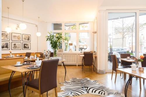 安德纳赫爱姆黑沃特斯图穆酒店的一间设有桌椅和斑马地毯的餐厅