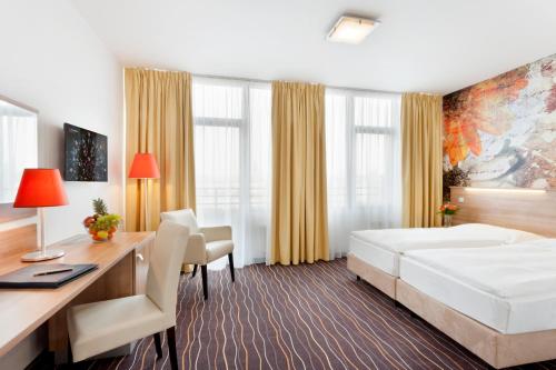 布拉格阿克森特酒店的配有一张床和一张书桌的酒店客房