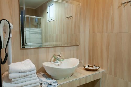 塞雷大都会酒店的浴室设有白色水槽和镜子