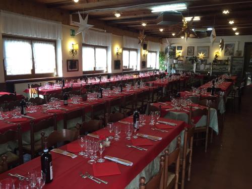 萨维尼奥内基娅拉酒店的配有长桌、红桌布和酒杯的房间
