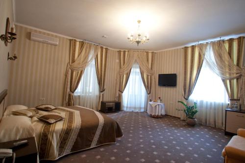 卡缅涅茨-波多利斯基Kleopatra VIP hotel的酒店客房设有一张床和两个窗户。