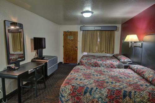 圣克拉拉圣克拉拉伊克诺旅店的配有一张床和一张书桌的酒店客房