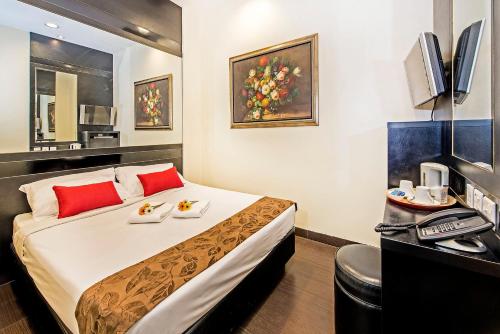 新加坡Hotel 81 Kovan的酒店客房配有一张带红色枕头的大床