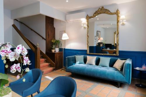 巴黎莫加多尔酒店的客厅配有蓝色的沙发和镜子